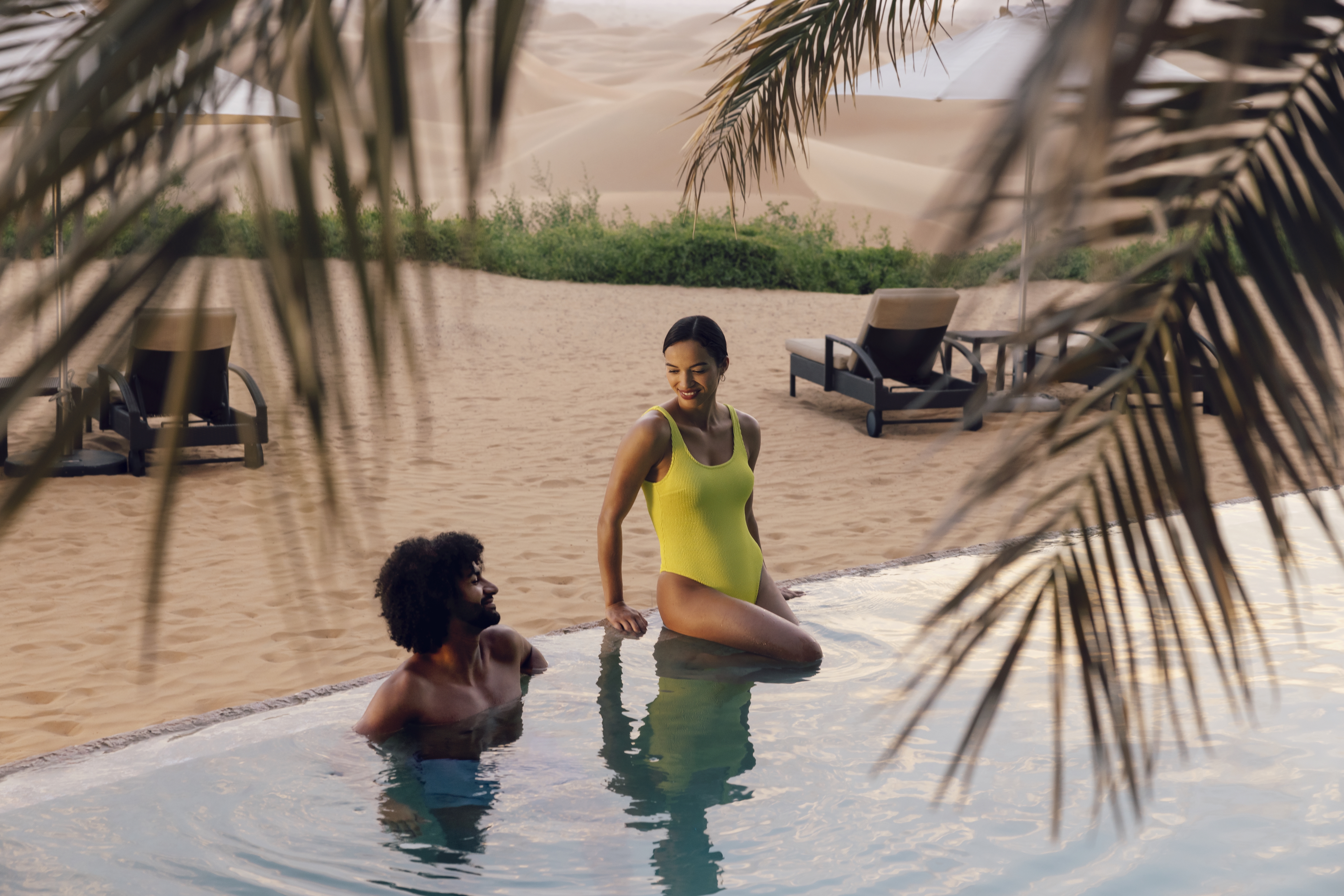 Couple enjoying the pool at a Telal Resort desert retreats
