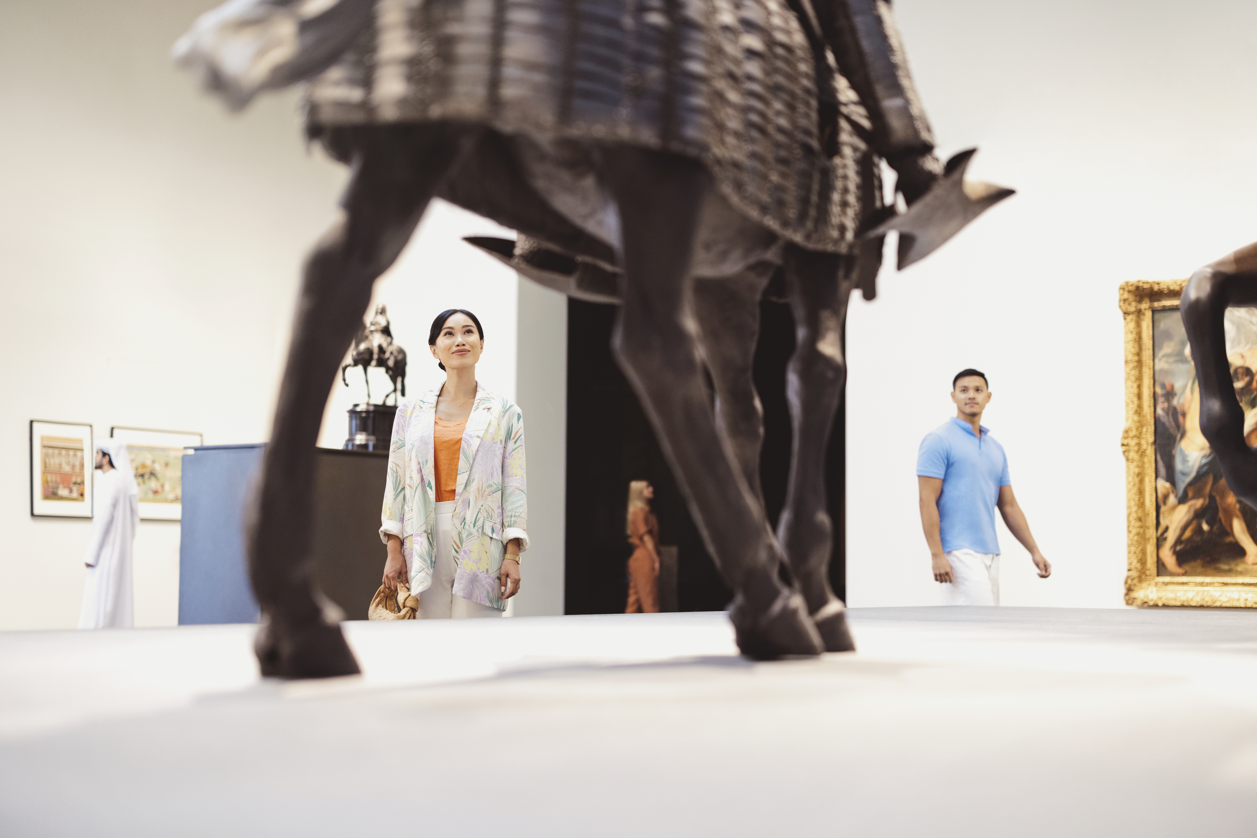 زوجان آسيويان يتأملان مجسم في متحف اللوفر أبوظبي