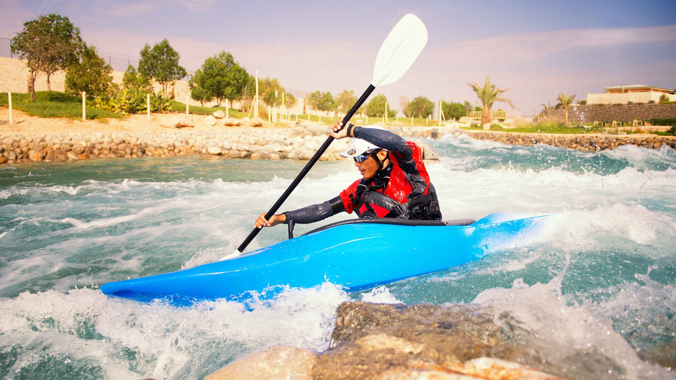 Man in a blue kayak kayaking in Abu Dhabi