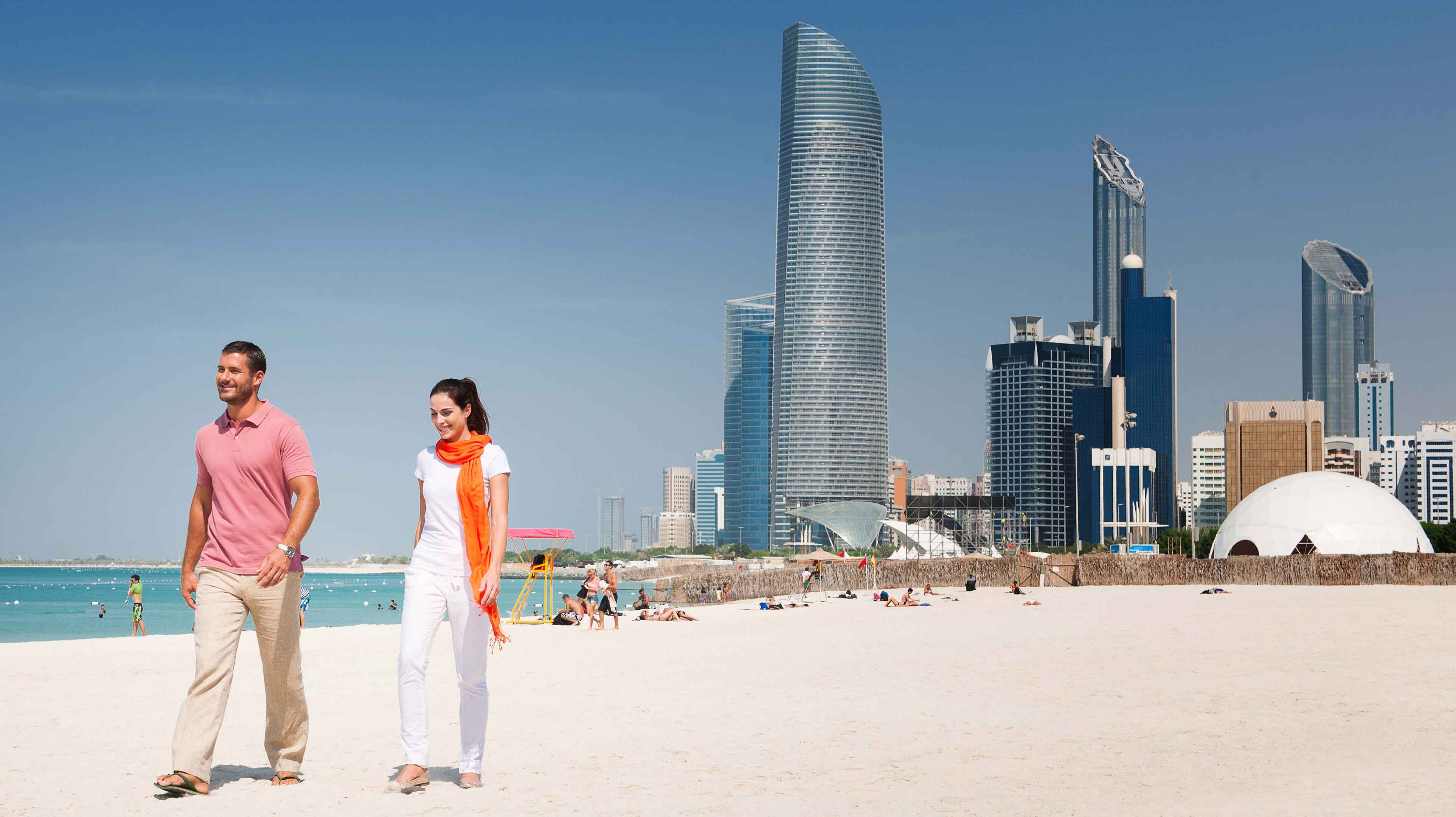 A couple taking a stroll on the beach at Abu Dhabi Corniche