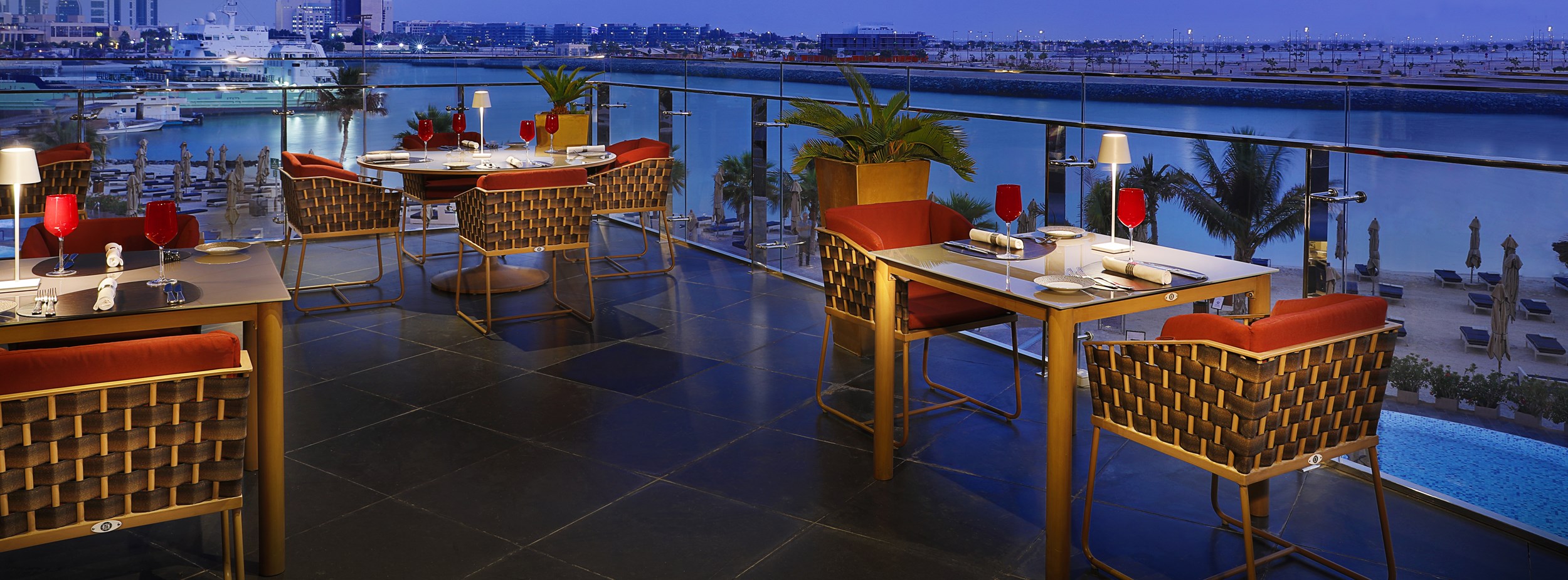 Dining area on a terrace overlooking the waters and skyline of Abu Dhabi