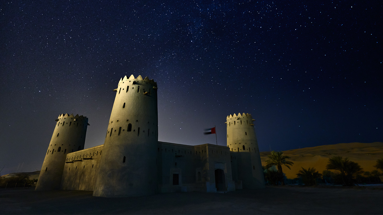 Un antico castello nel deserto di Abu Dhabi di notte sotto il cielo stellato