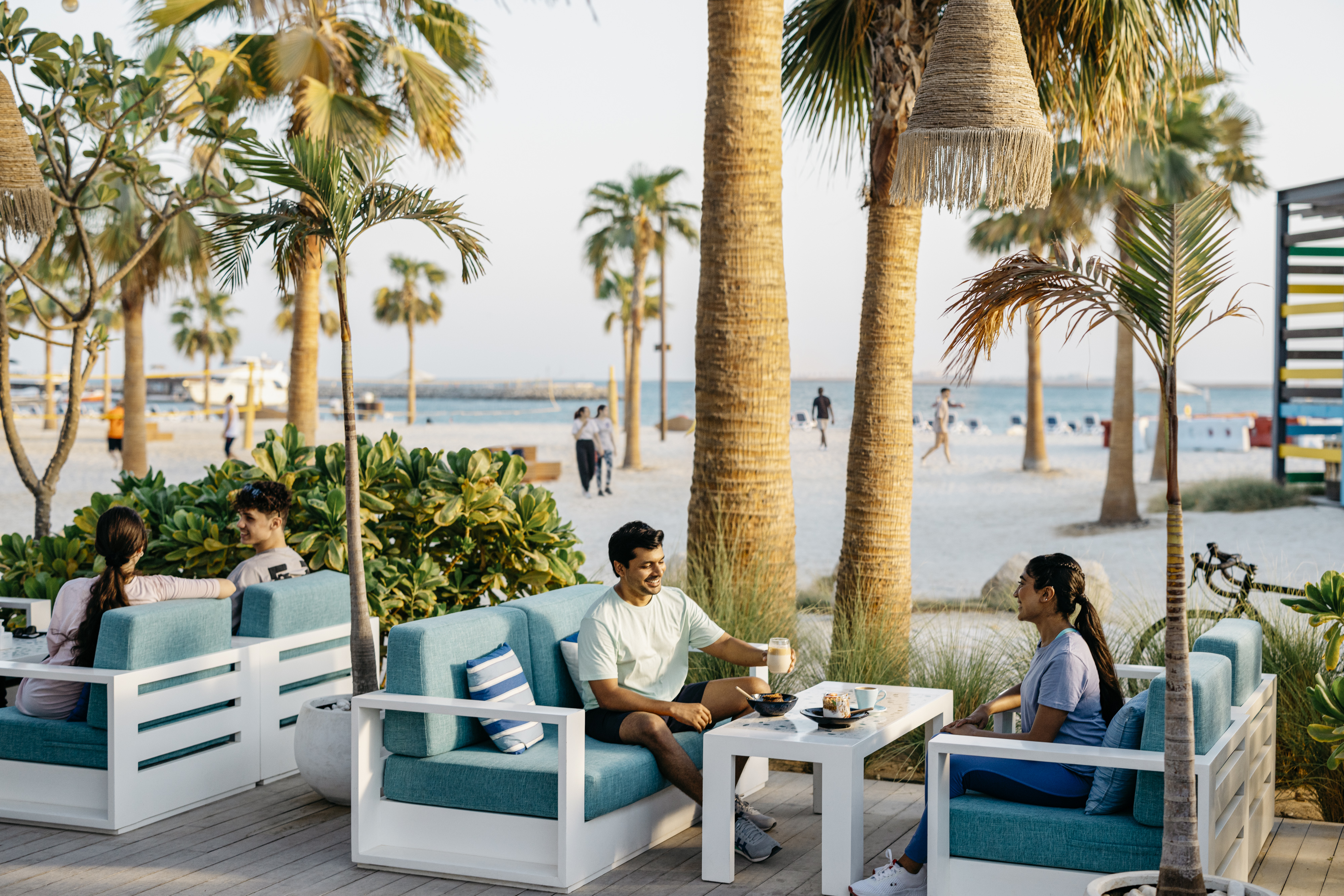 Man and woman enjoying coffee near the beach on Hudayriyat island