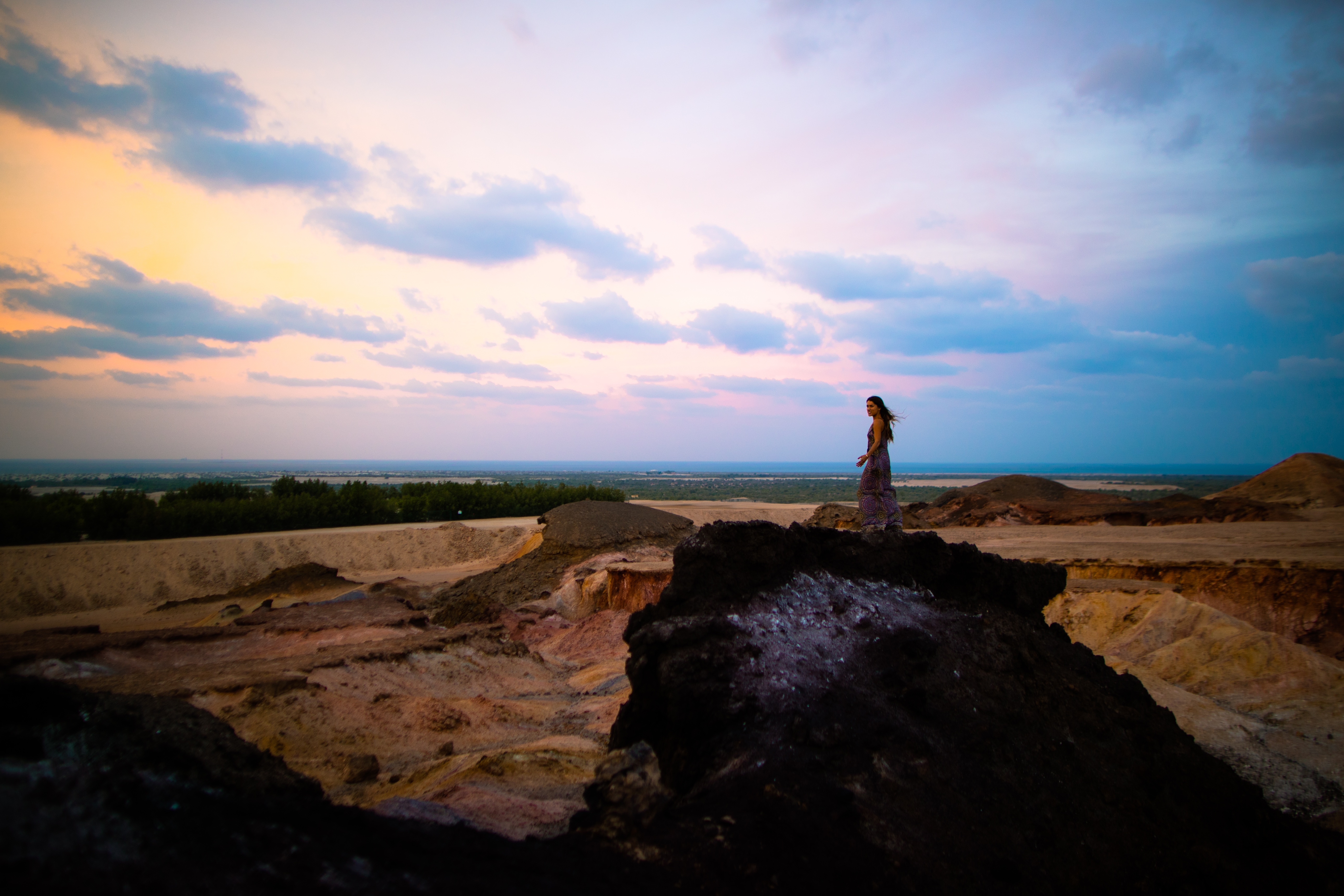Woman standing amidst naturally colourful rock formations on Sir Bani Yas Island